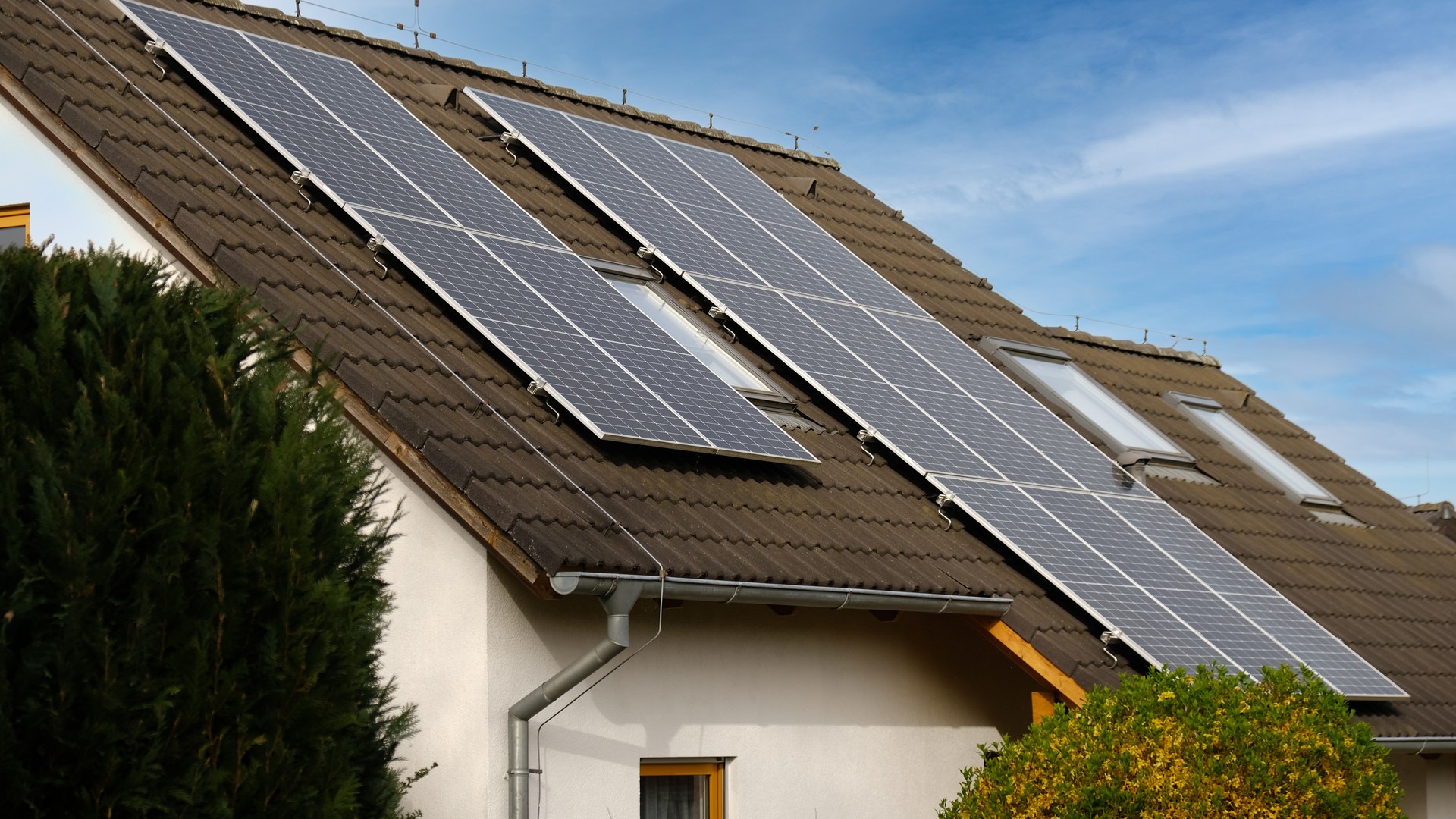 Home solar panel. Alternative energy is used for heating and water heating. Eco-friendly alternative energy for house. Residential family house suburban. Brown tile roof of home with solar panels.